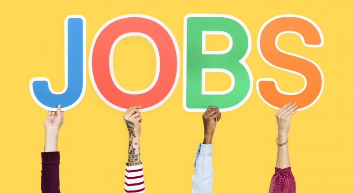 Hands holding up colorful letters forming the word jobs